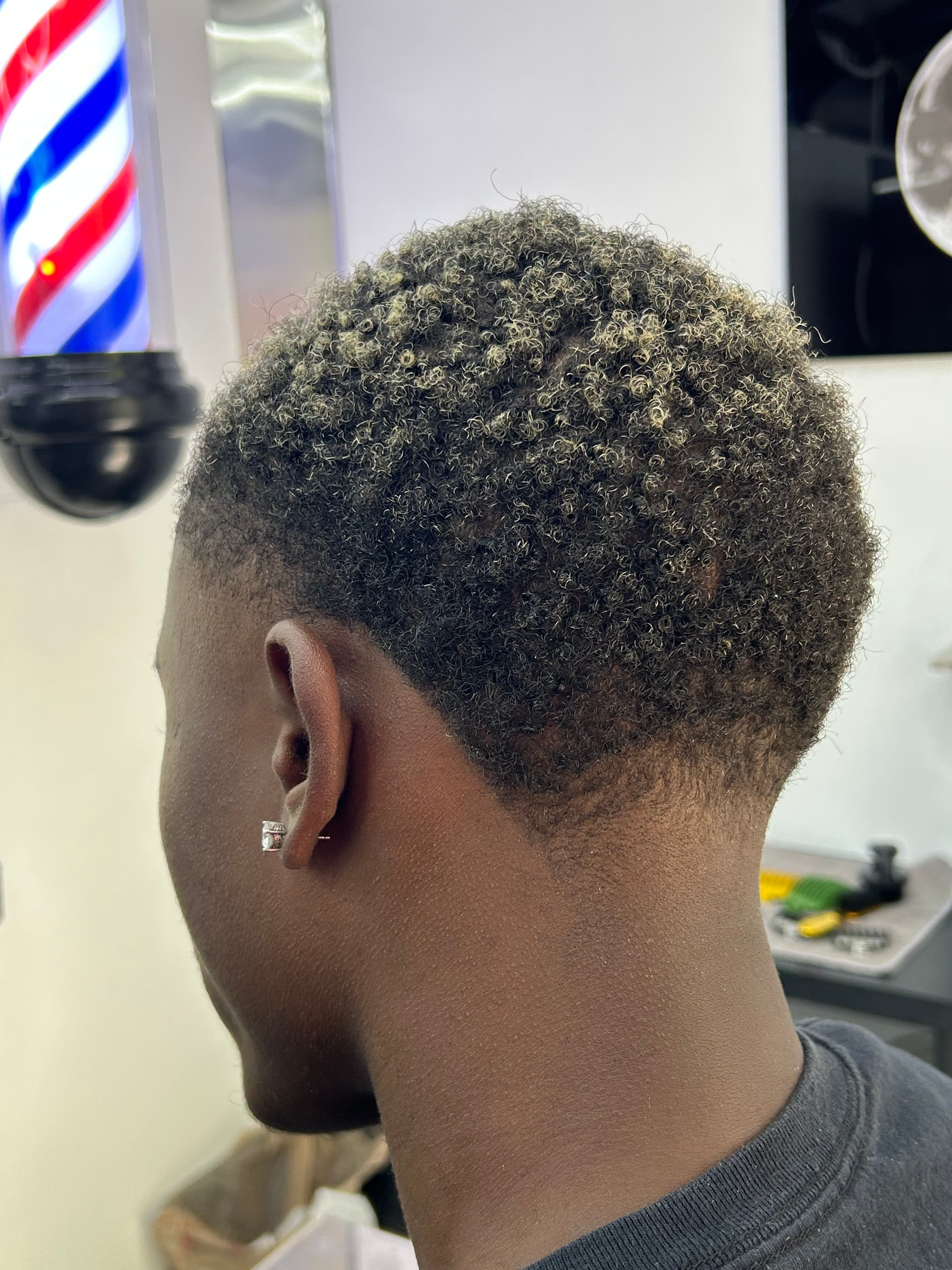 Tight curls with high skin fade, side view
